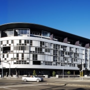 Exterior view of the apartment building looking from apartment, architecture, building, city, commercial building, condominium, corporate headquarters, facade, hotel, house, metropolis, mixed use, real estate, residential area, sky, teal