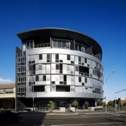 Exterior view of the apartment building looking from apartment, architecture, building, city, commercial building, condominium, corporate headquarters, daytime, elevation, facade, headquarters, house, metropolis, metropolitan area, mixed use, real estate, residential area, sky, blue, black
