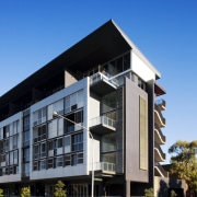 Exterior view of the apartment building looking from apartment, architecture, building, commercial building, condominium, corporate headquarters, elevation, facade, home, house, mixed use, neighbourhood, real estate, residential area, sky, blue, black