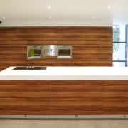 View of kitchen which features vinyl surfaces on cabinetry, chest of drawers, countertop, drawer, floor, furniture, hardwood, interior design, kitchen, plywood, wall, wood, wood flooring, wood stain, white, brown