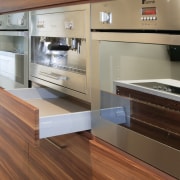 View of kitchen which features vinyl surfaces on cabinetry, countertop, cuisine classique, floor, hardwood, home appliance, interior design, kitchen, wood, brown, gray