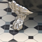 View of the traditional-styled bathtub with chrome foot-stands. chessboard, design, floor, flooring, black, white