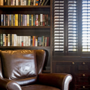 Image of dark stained library shelving and cabinetry bookcase, chair, furniture, home, interior design, library, living room, shelf, shelving, window, wood, black