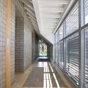 View of hallway which runs alongside the honed architecture, ceiling, daylighting, floor, flooring, house, interior design, lobby, structure, window, wood, gray