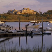 Exterior view of a large cottage with cedar boat, calm, coast, dawn, dock, dusk, evening, harbor, inlet, lake, loch, marina, morning, reflection, river, sea, sky, sunset, water, waterway, purple, brown