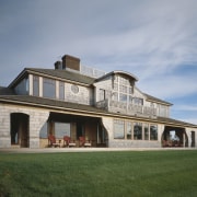 Exterior view of a large cottage with cedar cottage, elevation, estate, facade, farmhouse, home, house, mansion, property, real estate, residential area, siding, sky, villa, window, gray