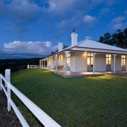 Exterior view of Victorian-syle house featuring steel roofing, architecture, cloud, cottage, estate, evening, facade, farmhouse, home, house, landscape, lighting, mansion, property, real estate, residential area, sky, villa, blue