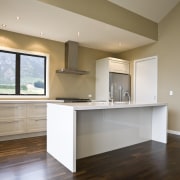 view of a show home kitchen where the cabinetry, ceiling, countertop, floor, flooring, hardwood, home, interior design, kitchen, laminate flooring, property, real estate, room, wood flooring, gray, brown