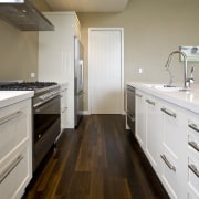 view of a show home kitchen where the bathroom, cabinetry, countertop, floor, flooring, hardwood, home, interior design, kitchen, property, real estate, room, sink, wood, gray, brown