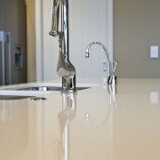 view of a show home kitchen where the floor, flooring, glass, product design, tap, gray