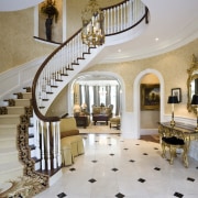 View of a sweeping staircase with dark-stained timber baluster, ceiling, estate, floor, flooring, handrail, home, interior design, lobby, property, real estate, stairs, gray, brown