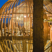 Image of the Yellow Treehouse restaurant which has architecture, landmark, light, lighting, night, reflection, sky, structure, tourist attraction, wood, brown, orange