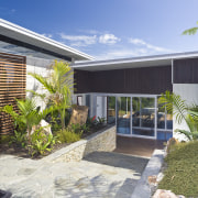 View of the exterior of this holiday home architecture, backyard, courtyard, estate, facade, home, house, outdoor structure, property, real estate, residential area, roof, villa, yard, gray