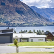 Exterior view of a home which features solar alps, cottage, elevation, estate, fjord, highland, home, house, lake, landscape, mountain, mountain range, property, real estate, residential area, roof, sky, suburb, tree, white