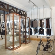 View of clothing displays which are separated by boutique, flooring, structure, white