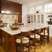 View of kitchen area which features a large cabinetry, countertop, cuisine classique, dining room, furniture, hardwood, interior design, kitchen, room, brown, white