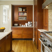 View of kitchen area which features a large cabinetry, countertop, cuisine classique, floor, flooring, hardwood, interior design, kitchen, room, wood, wood flooring, wood stain, brown