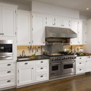 View of kitchen with white painted maple cabinetry, cabinetry, countertop, cuisine classique, floor, flooring, home appliance, kitchen, kitchen appliance, kitchen stove, room, gray