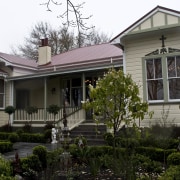 Exterior view of this Victorian presbytery. - Exterior architecture, building, cottage, estate, facade, historic house, home, house, mansion, neighbourhood, porch, property, real estate, residential area, roof, siding, suburb, tree, window, black