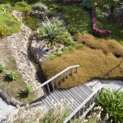 View of a landscaped garden which features a botanical garden, garden, grass, grass family, landscape, landscaping, path, plant, tree, vegetation, walkway, yard, brown