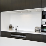 View of kitchen featuring dark-stained oak cabinetry, appliances, countertop, home appliance, interior design, kitchen, product design, white, black