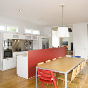 View of open-plan kitchen area which features an architecture, floor, flooring, furniture, home, house, interior design, kitchen, real estate, room, table, wood, white, orange