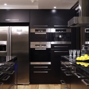 View of an apartment kitchen which features solid cabinetry, countertop, home appliance, interior design, kitchen, room, black