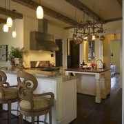 View of an open-plan kitchen featuring a central ceiling, countertop, interior design, kitchen, lighting, room, brown