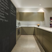 View of kitchen which features large blackboards, polished cabinetry, countertop, floor, flooring, interior design, kitchen, real estate, room, gray, brown