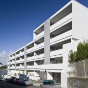 Exterior view of the Ivory apartments which features apartment, architecture, building, commercial building, condominium, corporate headquarters, elevation, facade, headquarters, house, mixed use, neighbourhood, parking, parking lot, property, real estate, residential area, sky, blue, white