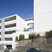 Exterior view of the Ivory apartments which features apartment, architecture, building, car, commercial building, condominium, corporate headquarters, daytime, elevation, facade, headquarters, house, metropolitan area, mixed use, property, real estate, residential area, sky, white, blue