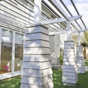 Exterior view of a new home designed by column, grass, outdoor structure, sculpture, structure, tree, gray