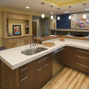 View of a kitchen which features a L-shaped cabinetry, countertop, cuisine classique, hardwood, interior design, kitchen, room, brown