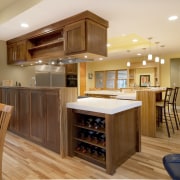 View of a kitchen which features a L-shaped cabinetry, ceiling, countertop, cuisine classique, floor, flooring, hardwood, interior design, kitchen, laminate flooring, real estate, room, wood, wood flooring, brown, orange