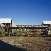 Exterior view of a canal-side beach house which architecture, building, corporate headquarters, estate, facade, home, house, property, real estate, residential area, sky, blue