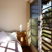 View of a bedroom which features a glass bedroom, daylighting, home, house, interior design, property, real estate, room, window, window covering, wood