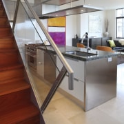 View of a small kitchen beneath a stairway architecture, countertop, floor, flooring, glass, handrail, hardwood, house, interior design, kitchen, laminate flooring, loft, stairs, wood, wood flooring, gray