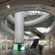 Interior view of the large public concourse between architecture, building, ceiling, convention center, daylighting, interior design, lobby, shopping mall, structure, gray, black