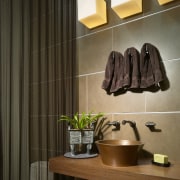View of a small powder room which features bathroom, ceiling, floor, flooring, interior design, room, tile, wall, brown