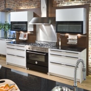 View of a contemporary kitchen which features a cabinetry, countertop, furniture, home appliance, kitchen, kitchen appliance, white