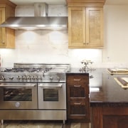 View of a contemporary kitchen which features a cabinetry, countertop, cuisine classique, furniture, hardwood, home appliance, interior design, kitchen, kitchen appliance, kitchen stove, room, white