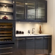 View of a kitchen which features kitchen cabinetry cabinetry, countertop, cuisine classique, interior design, kitchen, shelf, shelving, under cabinet lighting, black, orange