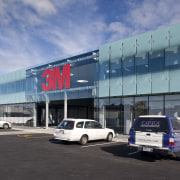 external view of 3M Head Office part of airport terminal, building, car, car dealership, commercial building, corporate headquarters, family car, infrastructure, luxury vehicle, metropolitan area, motor vehicle, sky, structure, transport, teal, black