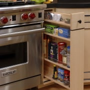 Designer Jennifer Gilmer, CKD, specified two islands for cabinetry, countertop, drawer, floor, flooring, gas stove, hardwood, home appliance, kitchen, kitchen appliance, kitchen stove, major appliance, microwave oven, oven, refrigerator, room, shelf, brown