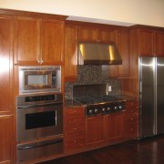 View of the condominiums kitchen before renovation cabinetry, countertop, cuisine classique, floor, flooring, furniture, hardwood, home appliance, interior design, kitchen, room, under cabinet lighting, red