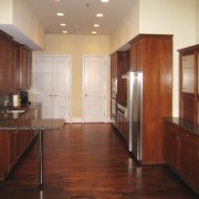 View of the condominiums kitchen before renovation. cabinetry, ceiling, countertop, cuisine classique, floor, flooring, furniture, hardwood, home, interior design, kitchen, laminate flooring, real estate, room, wall, wood, wood flooring, wood stain, red, orange