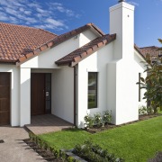 Exterior view of home featuring brick cladding, doors architecture, building, cottage, estate, facade, hacienda, home, house, property, real estate, residential area, roof, sky, villa, gray