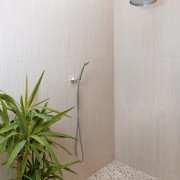 View of a bathroom which features a shower floor, interior design, plumbing fixture, property, tile, wall, wood, gray