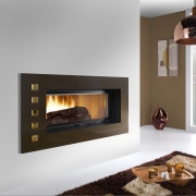 View of a living area which features a fireplace, hearth, heat, home appliance, wood burning stove, gray