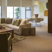 View of the lounge area of a unit ceiling, floor, flooring, furniture, hardwood, home, interior design, laminate flooring, living room, room, table, window, wood flooring, brown